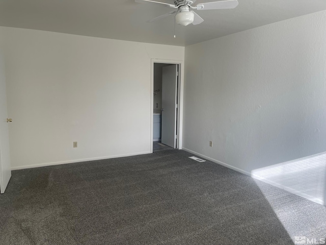 empty room with ceiling fan and dark colored carpet