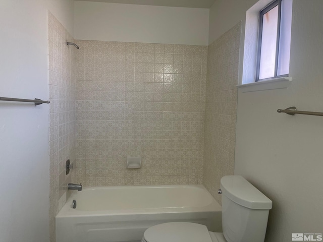 bathroom with toilet and tiled shower / bath