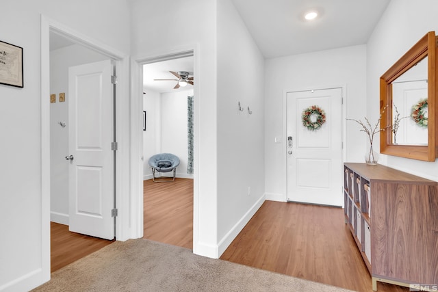 foyer with ceiling fan and light wood-type flooring