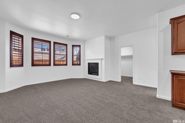 unfurnished living room with dark carpet