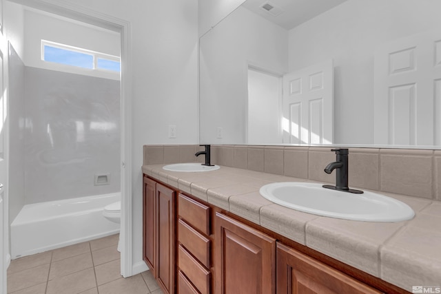 bathroom with toilet, vanity, and tile patterned floors