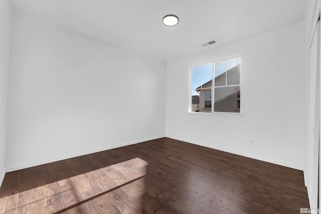 unfurnished room with dark hardwood / wood-style flooring