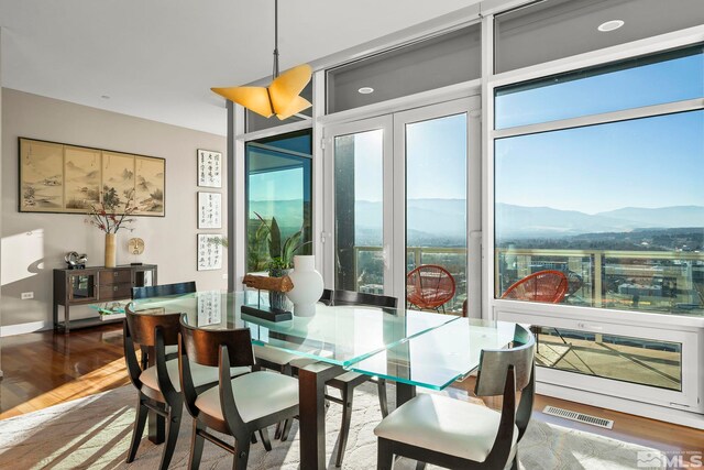 dining space with a mountain view and hardwood / wood-style flooring