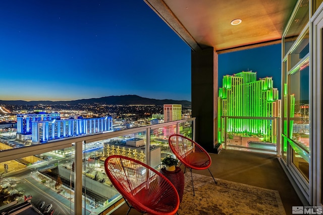 balcony at dusk featuring a mountain view