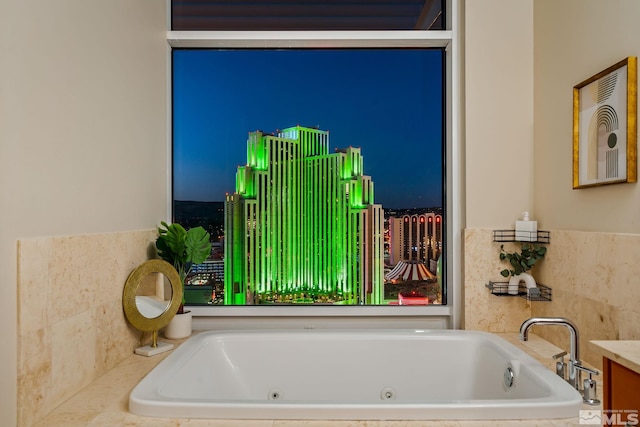 bathroom featuring a relaxing tiled tub and vanity