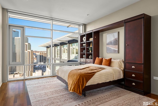 bedroom with hardwood / wood-style flooring and floor to ceiling windows