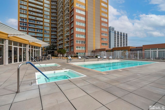 view of swimming pool featuring a hot tub