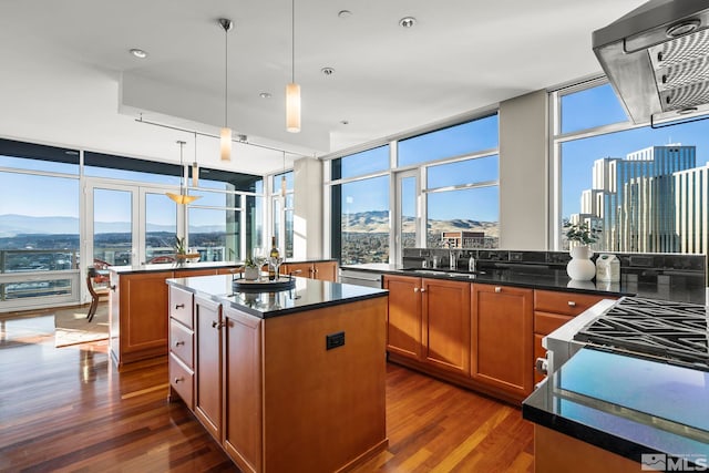 kitchen with dark wood-type flooring, a mountain view, a center island, and pendant lighting