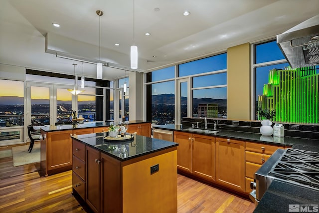 kitchen with decorative light fixtures, a kitchen island, a mountain view, and light wood-type flooring