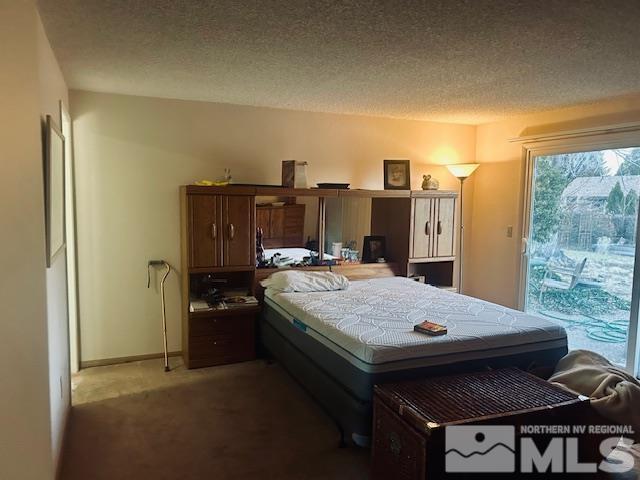 bedroom featuring a textured ceiling and carpet floors