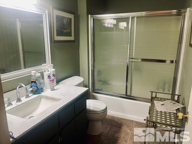 full bathroom with shower / bath combination with glass door, tile patterned floors, vanity, and toilet