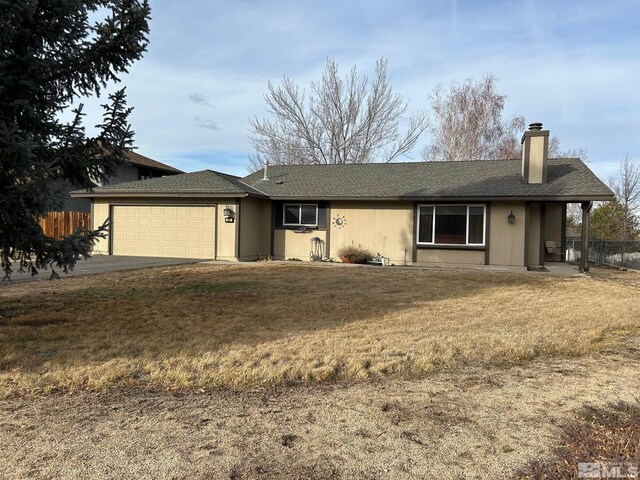 ranch-style house featuring a garage and a front lawn