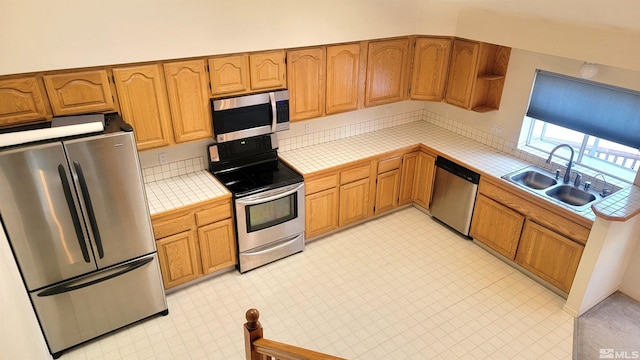 kitchen featuring appliances with stainless steel finishes, tile countertops, and sink