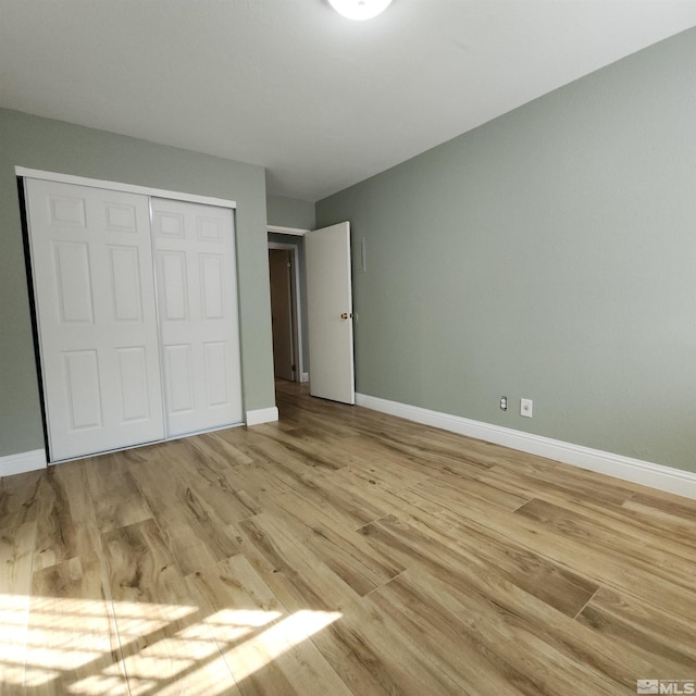 unfurnished bedroom featuring light wood-type flooring and a closet