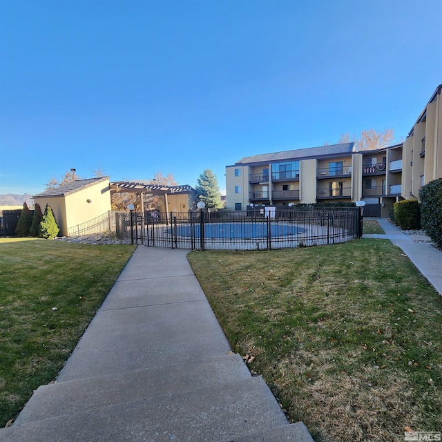 view of home's community featuring a lawn and a pool