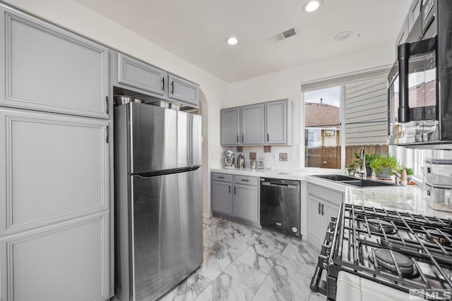 kitchen featuring appliances with stainless steel finishes, gray cabinets, and sink