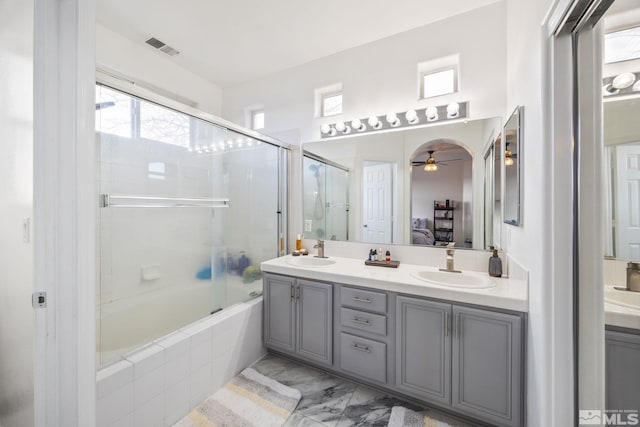 bathroom featuring combined bath / shower with glass door, vanity, and ceiling fan