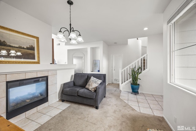 living room featuring light carpet, a chandelier, and a fireplace