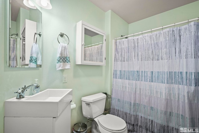 bathroom featuring vanity, toilet, and walk in shower