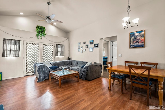 living room with ceiling fan with notable chandelier, wood-type flooring, and lofted ceiling