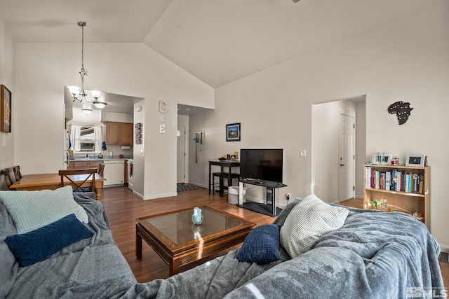 living room with dark hardwood / wood-style flooring, high vaulted ceiling, and a notable chandelier