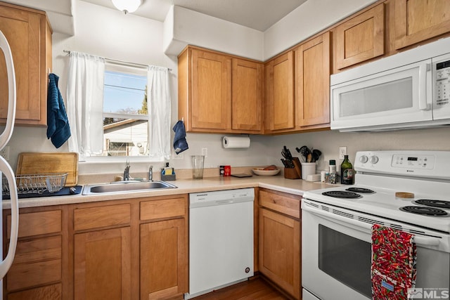 kitchen featuring white appliances, sink, and dark wood-type flooring