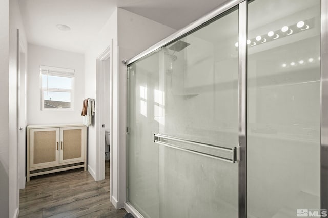 bathroom with hardwood / wood-style floors, toilet, and walk in shower