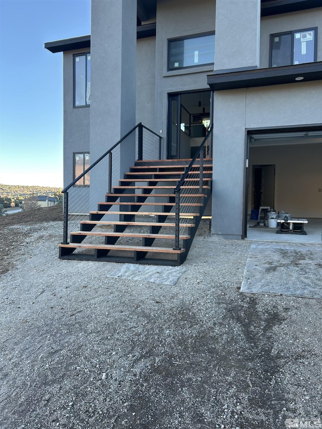 view of exterior entry featuring an attached garage and stucco siding