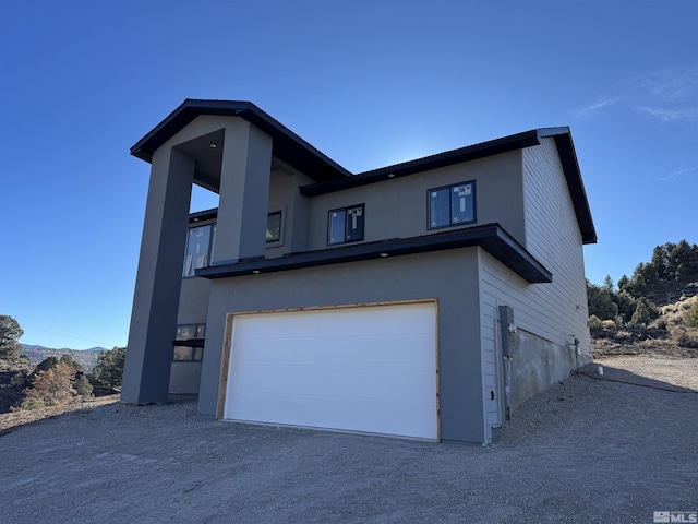 view of front facade with a garage and stucco siding