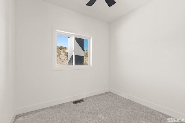 unfurnished room with carpet, visible vents, and baseboards