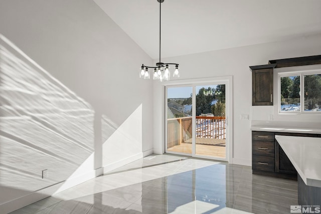 dining space with an inviting chandelier, vaulted ceiling, and baseboards