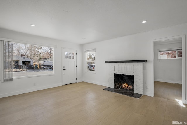 unfurnished living room featuring a fireplace and light hardwood / wood-style flooring