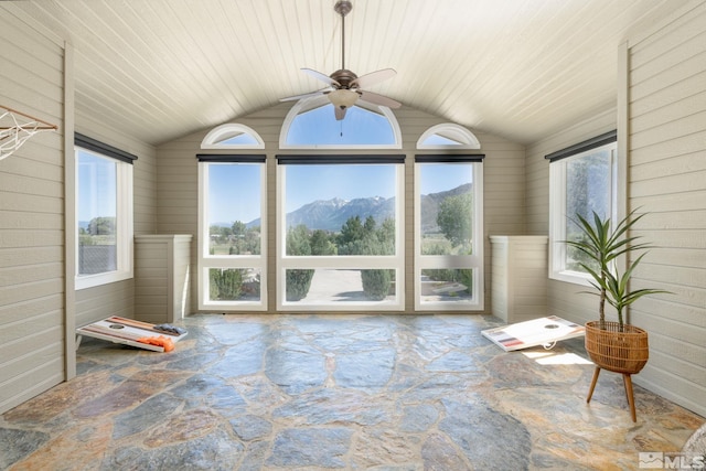 unfurnished sunroom featuring a mountain view, ceiling fan, wooden ceiling, and vaulted ceiling