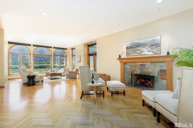 living room featuring light parquet flooring and a stone fireplace