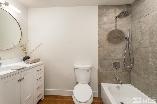 full bathroom featuring hardwood / wood-style floors, vanity, toilet, and tiled shower / bath