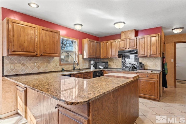 kitchen with decorative backsplash, sink, light tile patterned floors, and stone countertops