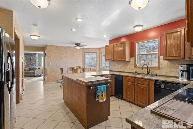 kitchen featuring ceiling fan, dishwasher, sink, stainless steel refrigerator with ice dispenser, and a textured ceiling