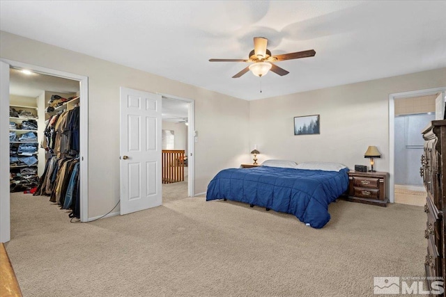 bedroom with ceiling fan, a closet, light colored carpet, and a spacious closet