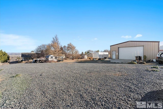 view of yard featuring a garage and an outbuilding