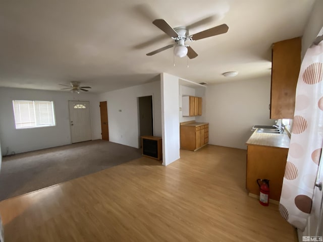 interior space featuring ceiling fan, light wood-type flooring, and sink