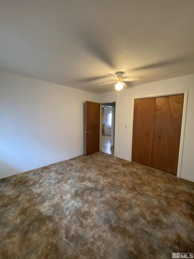 unfurnished bedroom with carpet, ceiling fan, and a closet