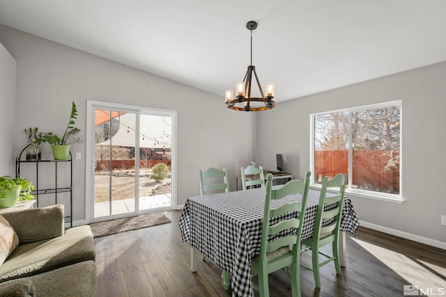 dining room featuring a healthy amount of sunlight, dark hardwood / wood-style flooring, and a chandelier