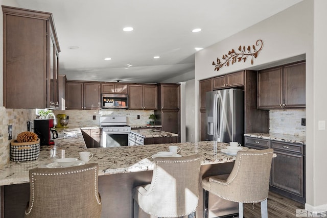 kitchen featuring backsplash, light stone countertops, and stainless steel appliances