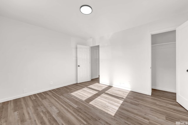 unfurnished bedroom featuring a closet and hardwood / wood-style flooring