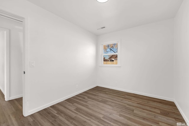 unfurnished room with dark wood-type flooring