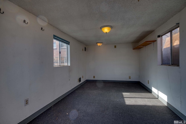 empty room featuring a textured ceiling and a wealth of natural light