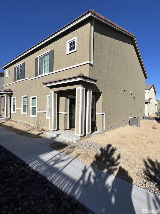 rear view of house featuring central AC unit