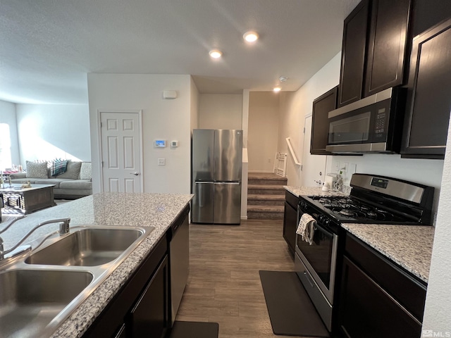 kitchen featuring hardwood / wood-style floors, dark brown cabinetry, stainless steel appliances, and sink