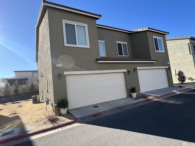 view of front of property with a garage and central AC unit