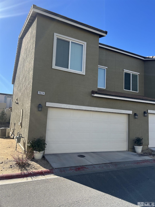 view of front of home with central AC and a garage